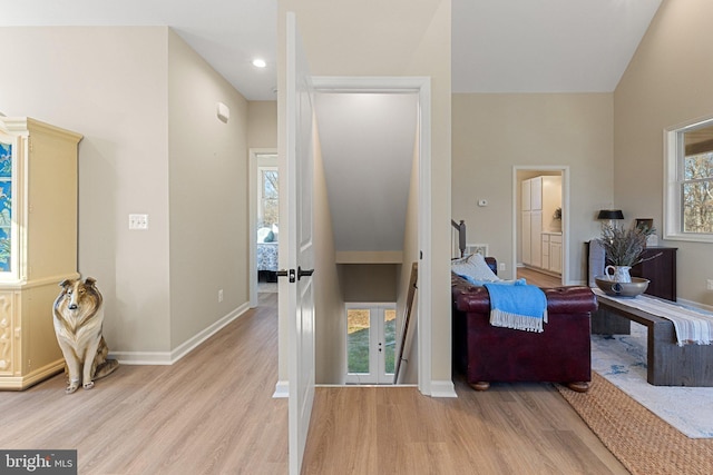 interior space with a towering ceiling and light hardwood / wood-style flooring