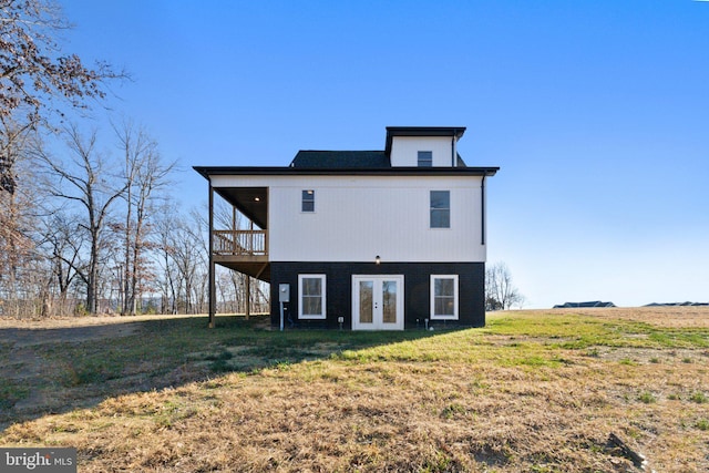 rear view of house with french doors and a lawn