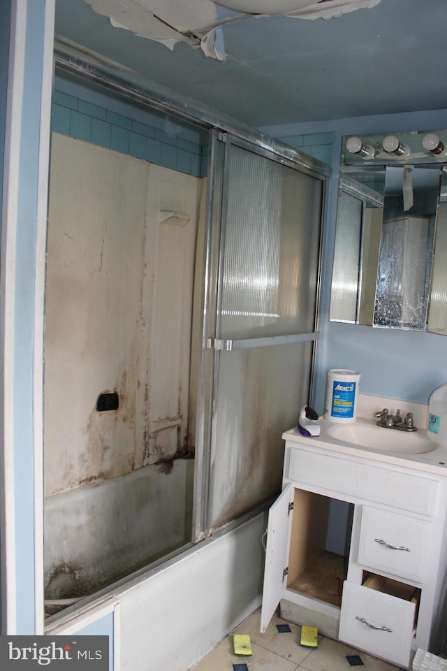 bathroom with vanity and bath / shower combo with glass door