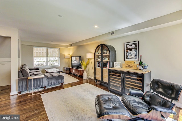 living room with dark hardwood / wood-style floors and bar