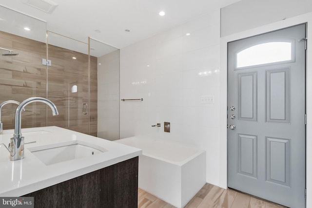 bathroom featuring hardwood / wood-style floors, vanity, and separate shower and tub