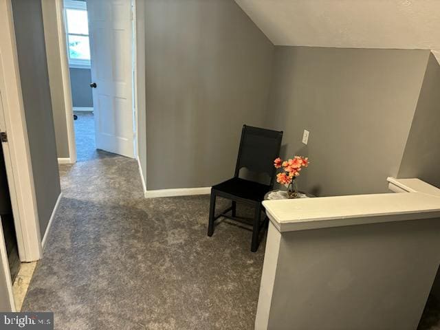 living area featuring dark carpet and lofted ceiling