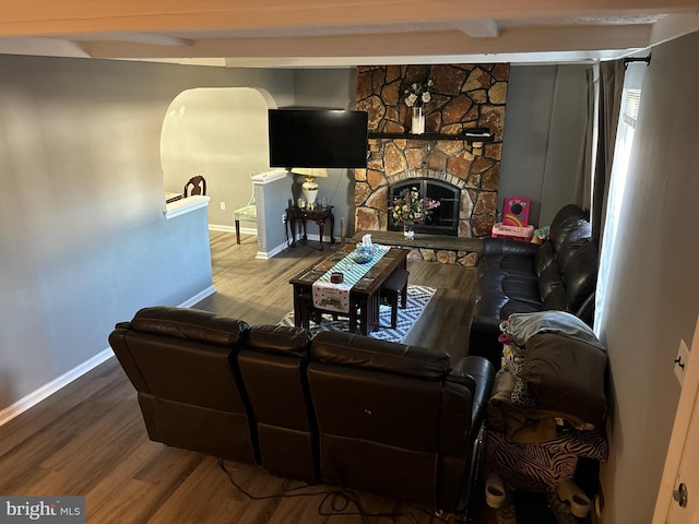 living room featuring a fireplace, hardwood / wood-style flooring, and beamed ceiling