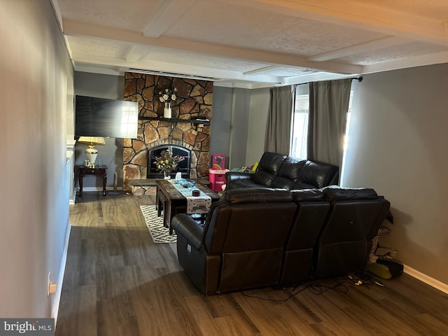 living room with beam ceiling, a fireplace, wood-type flooring, and a textured ceiling