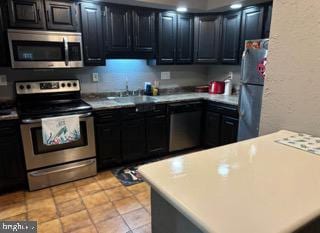 kitchen featuring light tile patterned flooring, sink, and appliances with stainless steel finishes