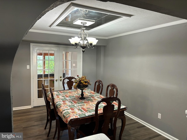 dining area featuring crown molding, french doors, a chandelier, and dark hardwood / wood-style floors