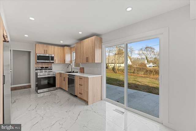 kitchen featuring light brown cabinetry, decorative backsplash, sink, and stainless steel appliances