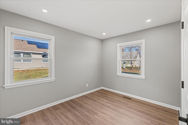 spare room with light hardwood / wood-style floors and plenty of natural light