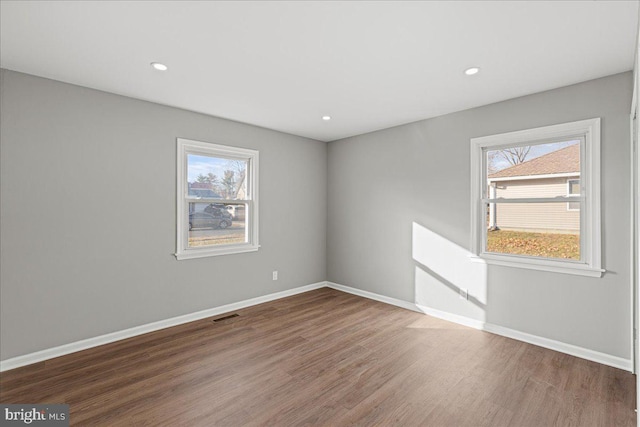 spare room featuring plenty of natural light and hardwood / wood-style floors