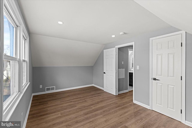 additional living space featuring dark hardwood / wood-style floors and lofted ceiling