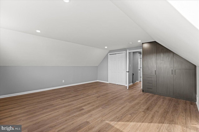 bonus room featuring vaulted ceiling and light wood-type flooring