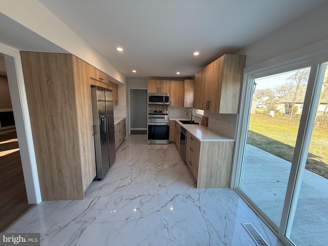 kitchen featuring decorative backsplash, sink, and stainless steel appliances