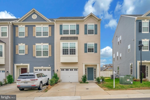 townhome / multi-family property featuring central AC unit and a garage