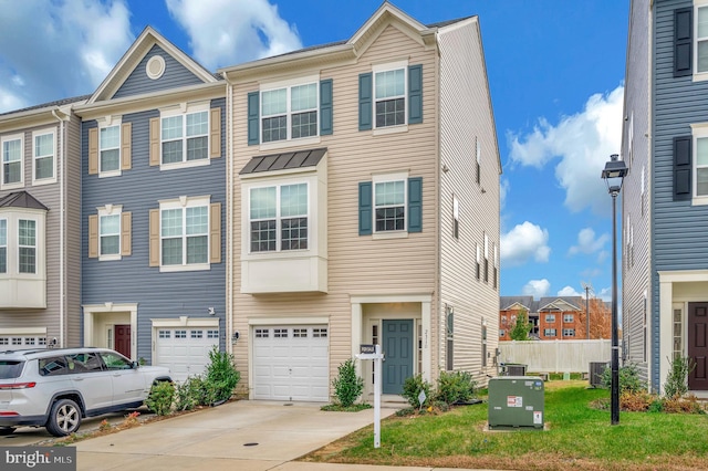 townhome / multi-family property with a garage and a front lawn