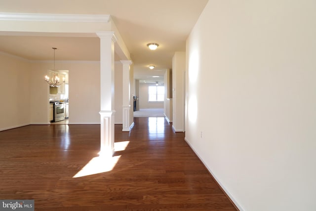 corridor featuring dark hardwood / wood-style flooring, decorative columns, crown molding, and a chandelier