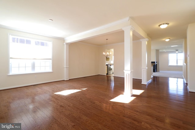 unfurnished living room with crown molding, dark wood-type flooring, and an inviting chandelier