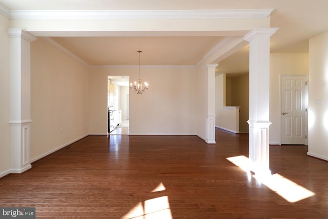 unfurnished room with a notable chandelier, dark hardwood / wood-style flooring, ornamental molding, and ornate columns