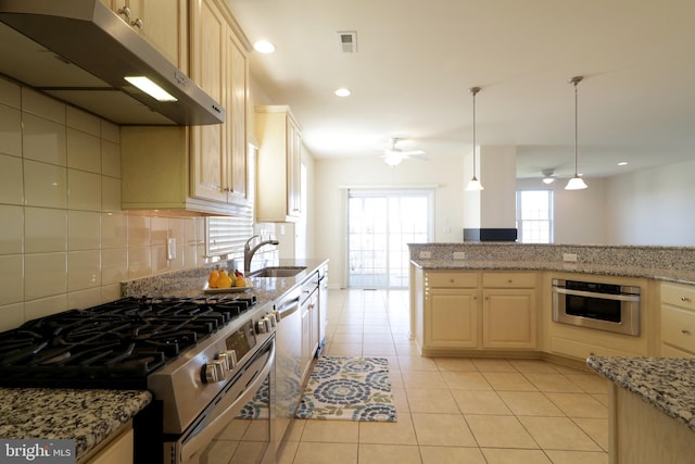 kitchen featuring sink, hanging light fixtures, ceiling fan, light tile patterned floors, and stainless steel appliances