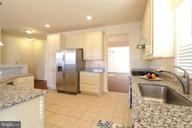 kitchen with cream cabinets, sink, light stone countertops, light tile patterned flooring, and stainless steel fridge with ice dispenser