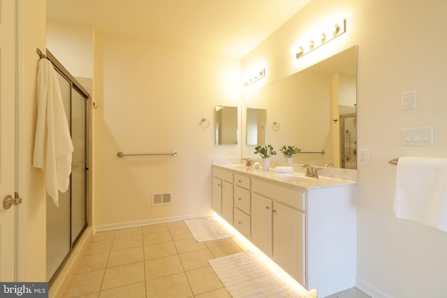 bathroom featuring tile patterned flooring, vanity, and an enclosed shower