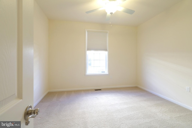 carpeted spare room featuring ceiling fan