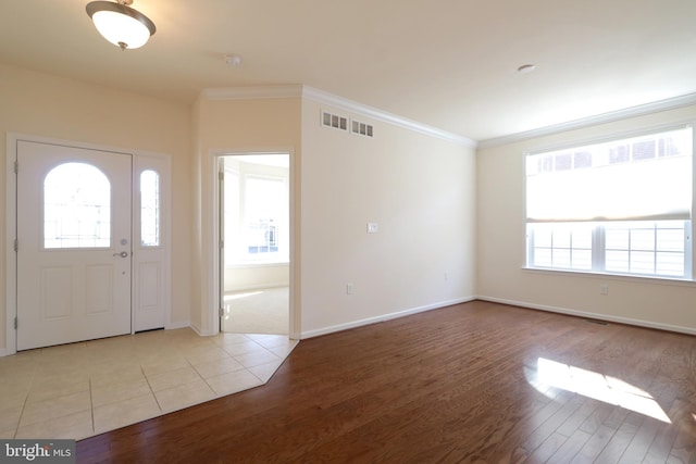 entryway with light wood-type flooring and crown molding