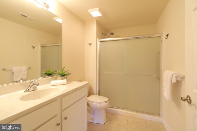 bathroom with tile patterned floors, a shower with door, vanity, and toilet