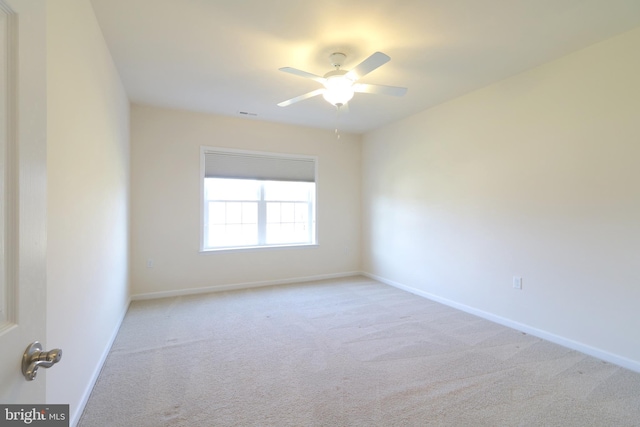 carpeted spare room with ceiling fan