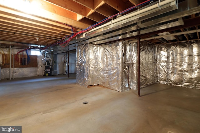 basement featuring heating unit and water heater