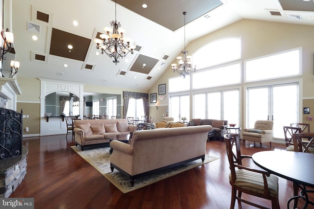 living room with a stone fireplace, a healthy amount of sunlight, and a high ceiling