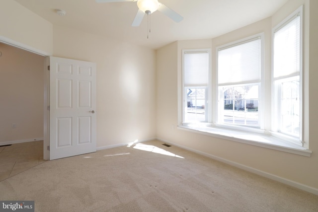 unfurnished room with ceiling fan and light colored carpet