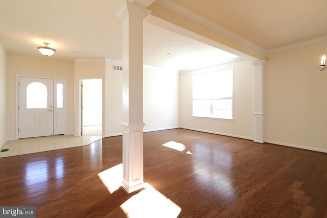 foyer featuring ornate columns, a wealth of natural light, and ornamental molding