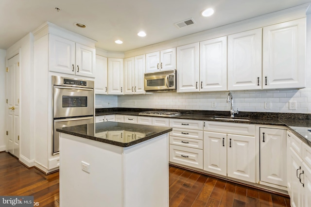 kitchen with white cabinets, a kitchen island, dark hardwood / wood-style flooring, and appliances with stainless steel finishes