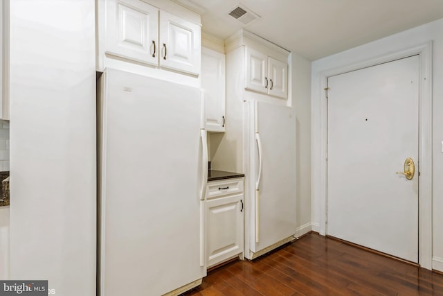 kitchen with white fridge, dark hardwood / wood-style flooring, and white cabinetry