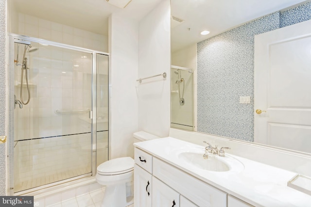 bathroom with tile patterned flooring, vanity, toilet, and a shower with door