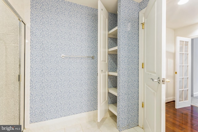 7902 Brynmor Ct Unit 201, Pikesville, MD 21208 - full bathroom featuring a walk in closet, a stall shower, baseboards, and wood finished floors