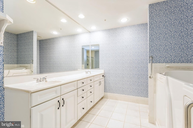 bathroom featuring tile patterned floors, vanity, and a tub