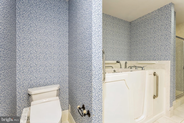 bathroom with tile patterned floors, toilet, and walk in shower