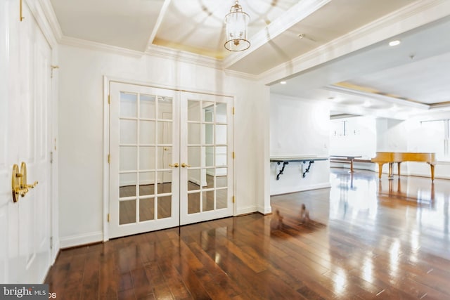 interior space featuring french doors, a raised ceiling, crown molding, dark wood-type flooring, and an inviting chandelier