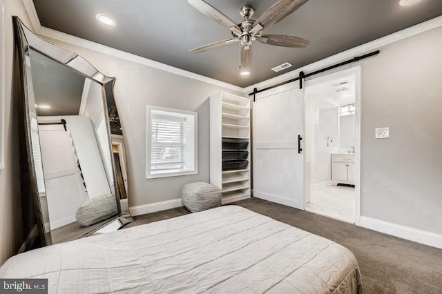 bedroom with a barn door, dark carpet, ceiling fan, and ornamental molding