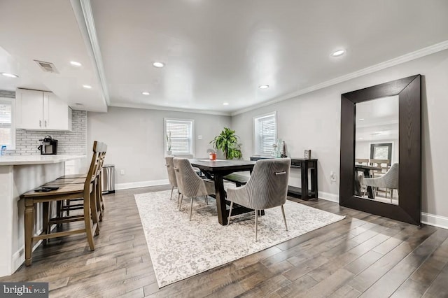 dining area featuring dark hardwood / wood-style flooring and ornamental molding