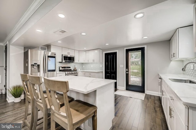 kitchen featuring white cabinetry, sink, tasteful backsplash, dark hardwood / wood-style flooring, and appliances with stainless steel finishes