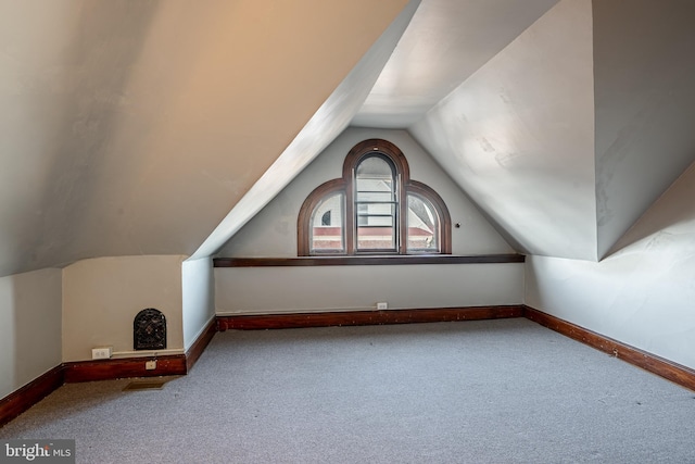 bonus room with carpet floors and vaulted ceiling