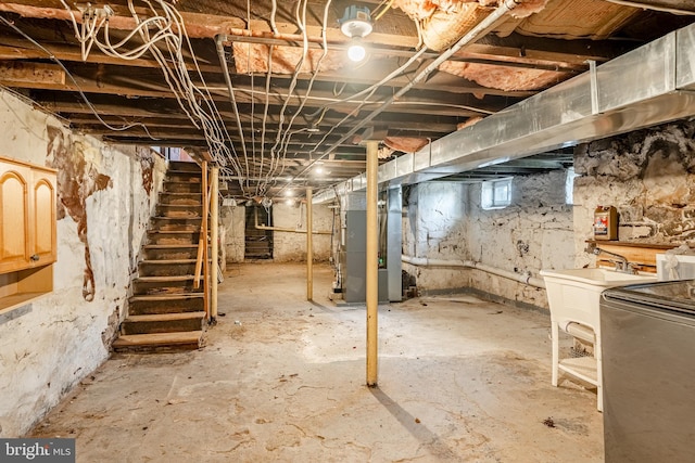 basement with heating unit, sink, and washer / dryer