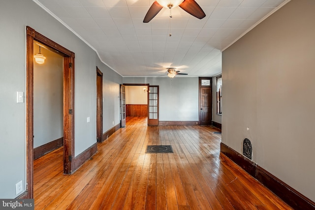 unfurnished room with ceiling fan, light hardwood / wood-style floors, ornamental molding, and french doors