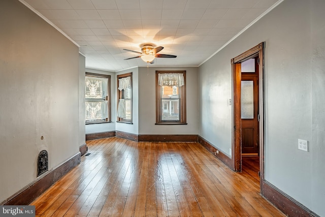 unfurnished room with hardwood / wood-style floors, plenty of natural light, ceiling fan, and crown molding