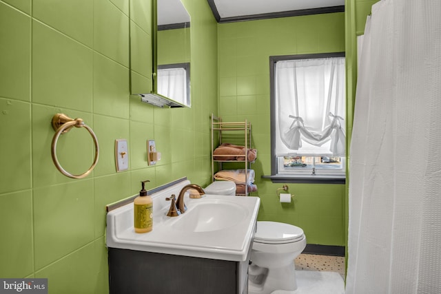 bathroom with ornamental molding, vanity, tile walls, toilet, and curtained shower