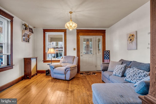 living room featuring a notable chandelier and light wood-type flooring