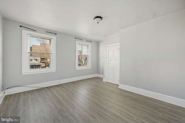 spare room featuring a healthy amount of sunlight and hardwood / wood-style flooring