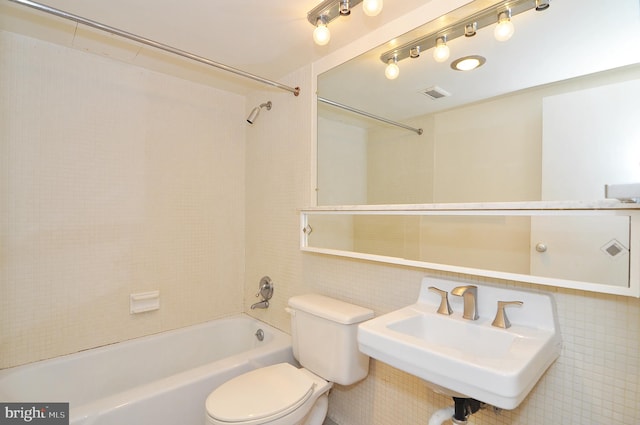 full bathroom with shower / tub combination, sink, tile walls, and toilet